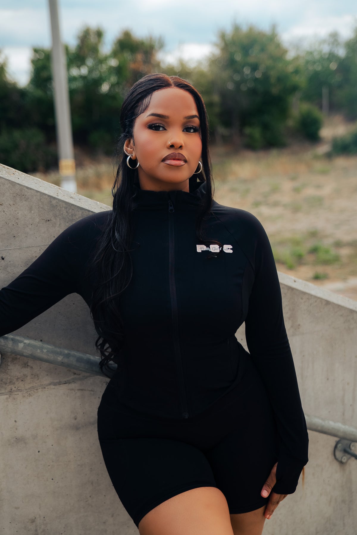 Model wearing Pretty Girl Club black fitted lounge jacket with pink PGC logo