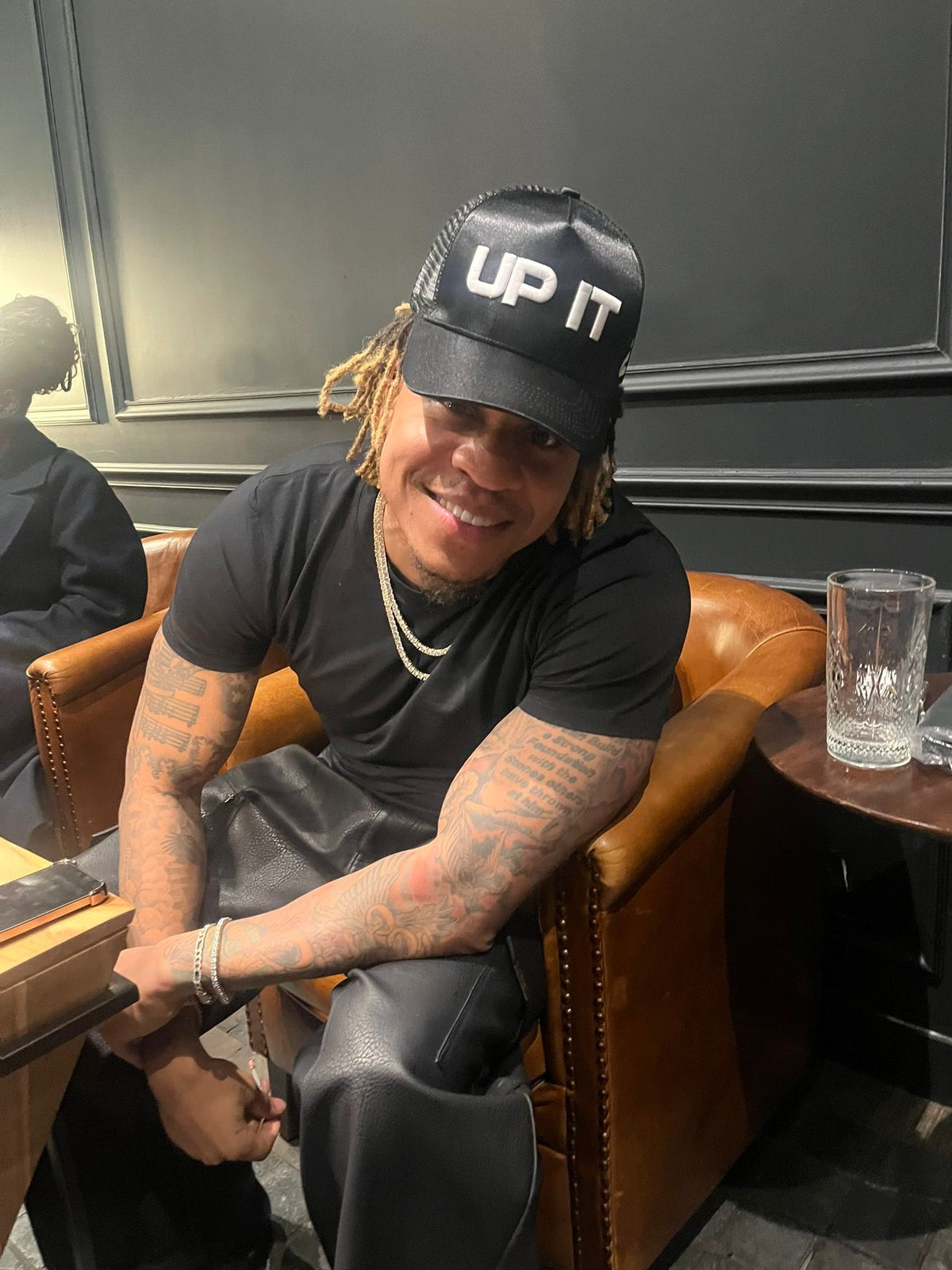 Rotimi wearing the UP IT Black Trucker Cap