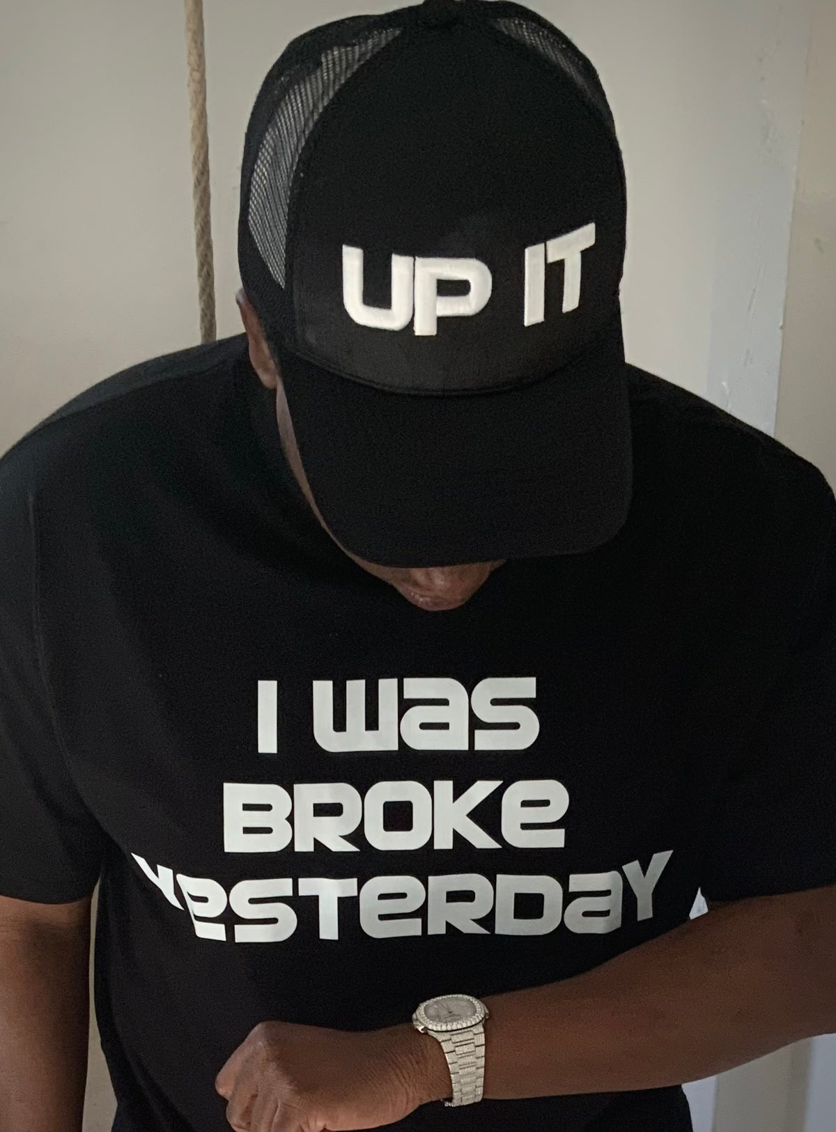 Model wearing UP IT black trucker cap and I was Broke Yesterday oversized black T-shirt